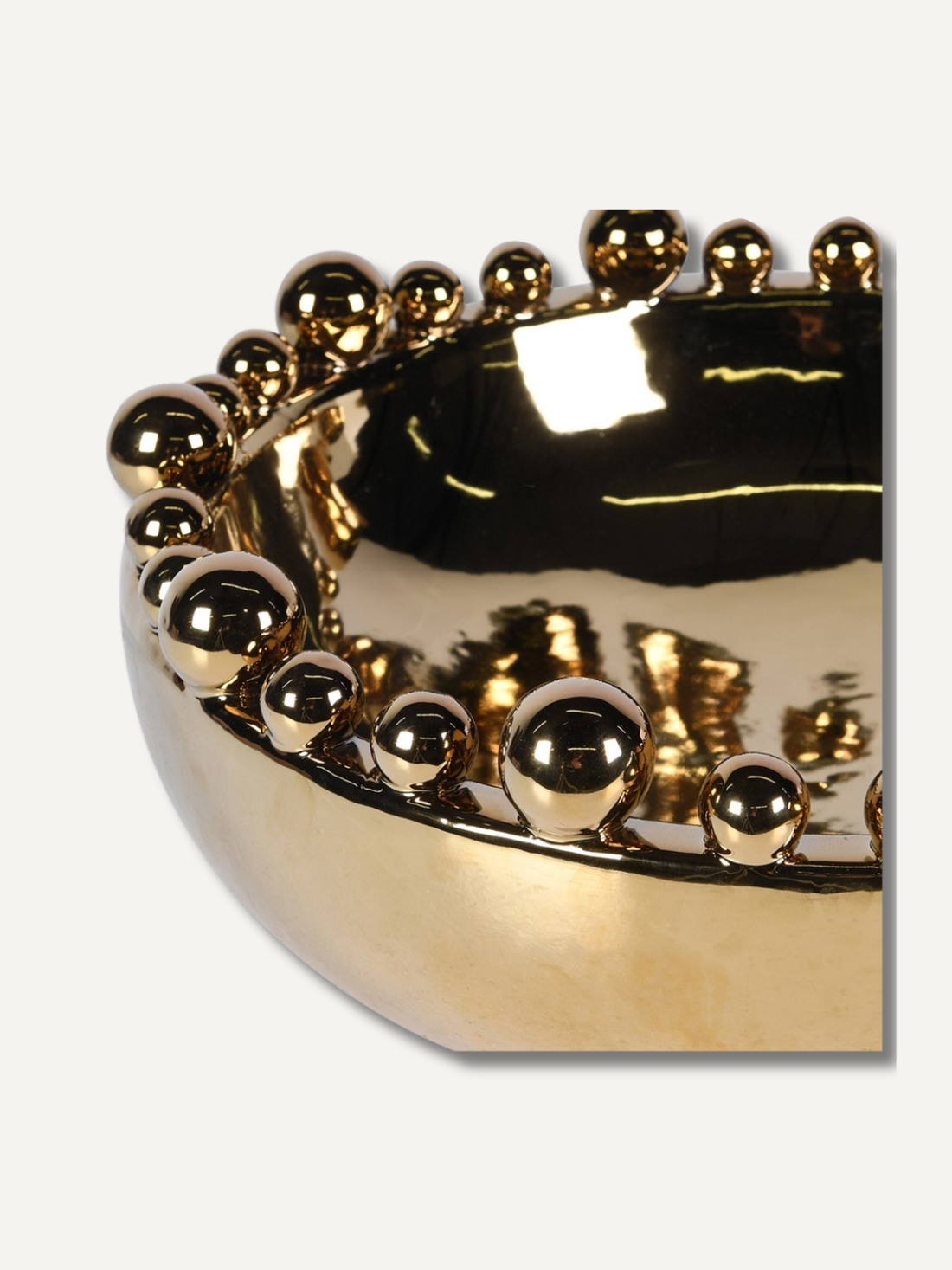 Gold decorative bowl with bobble embellishments on a white background