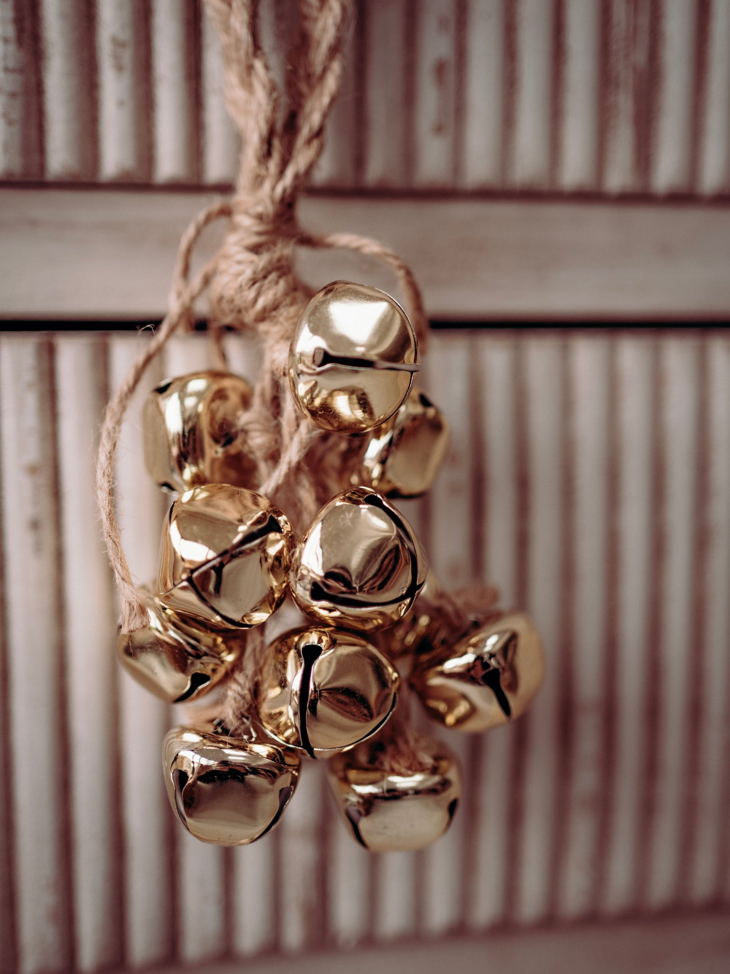 Gold jingle bells on a string against a wooden background