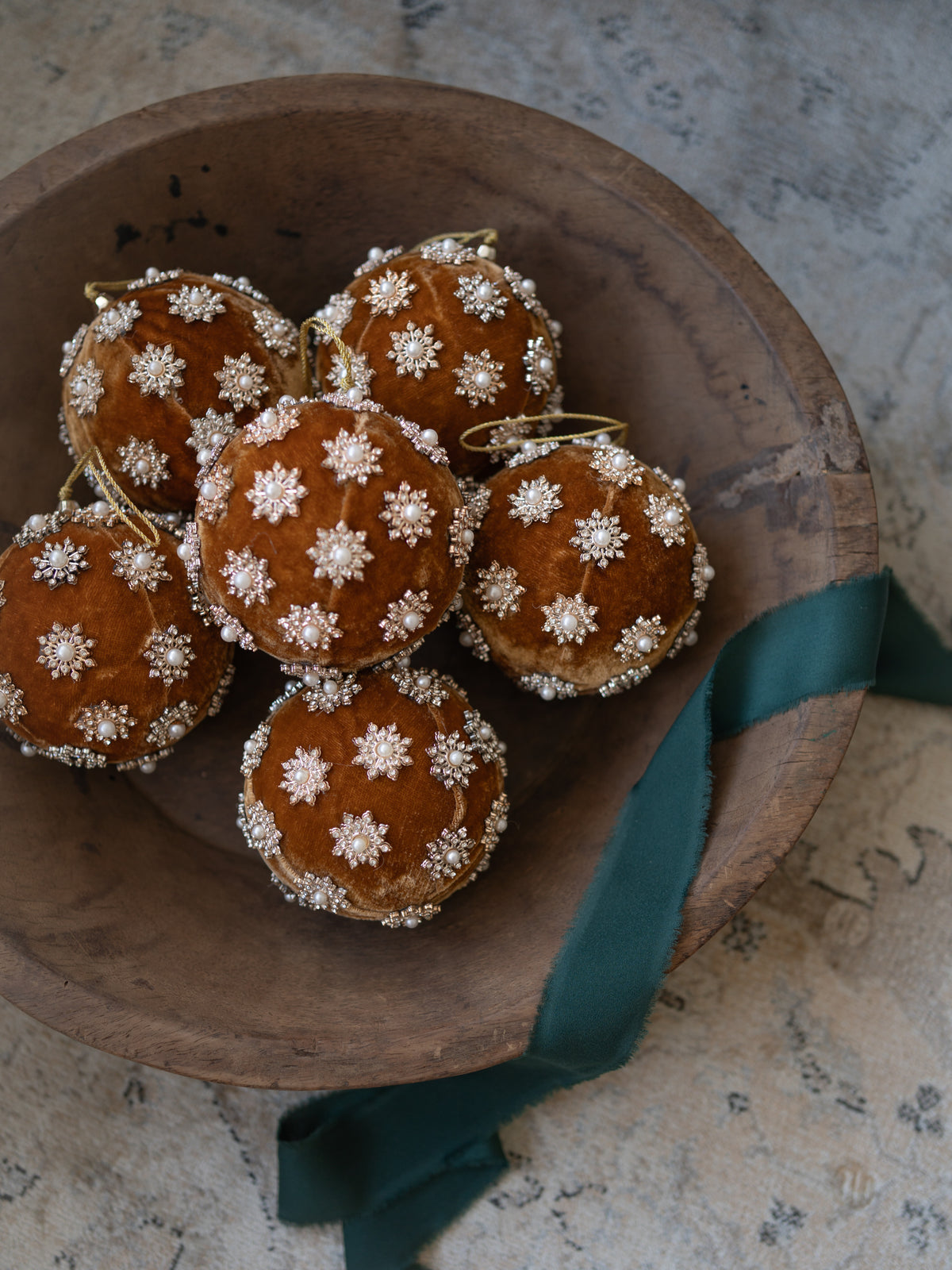 Gold Pearl Christmas Tree Bauble in rustic wooden bowl with emerald ribbon