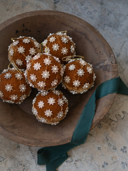 Gold Pearl Christmas Tree Bauble in rustic wooden bowl with emerald ribbon
