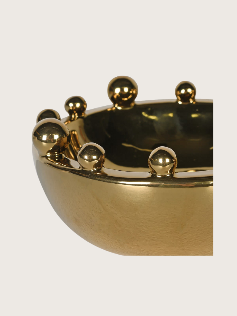 Gold bobble bowl on a light gray background