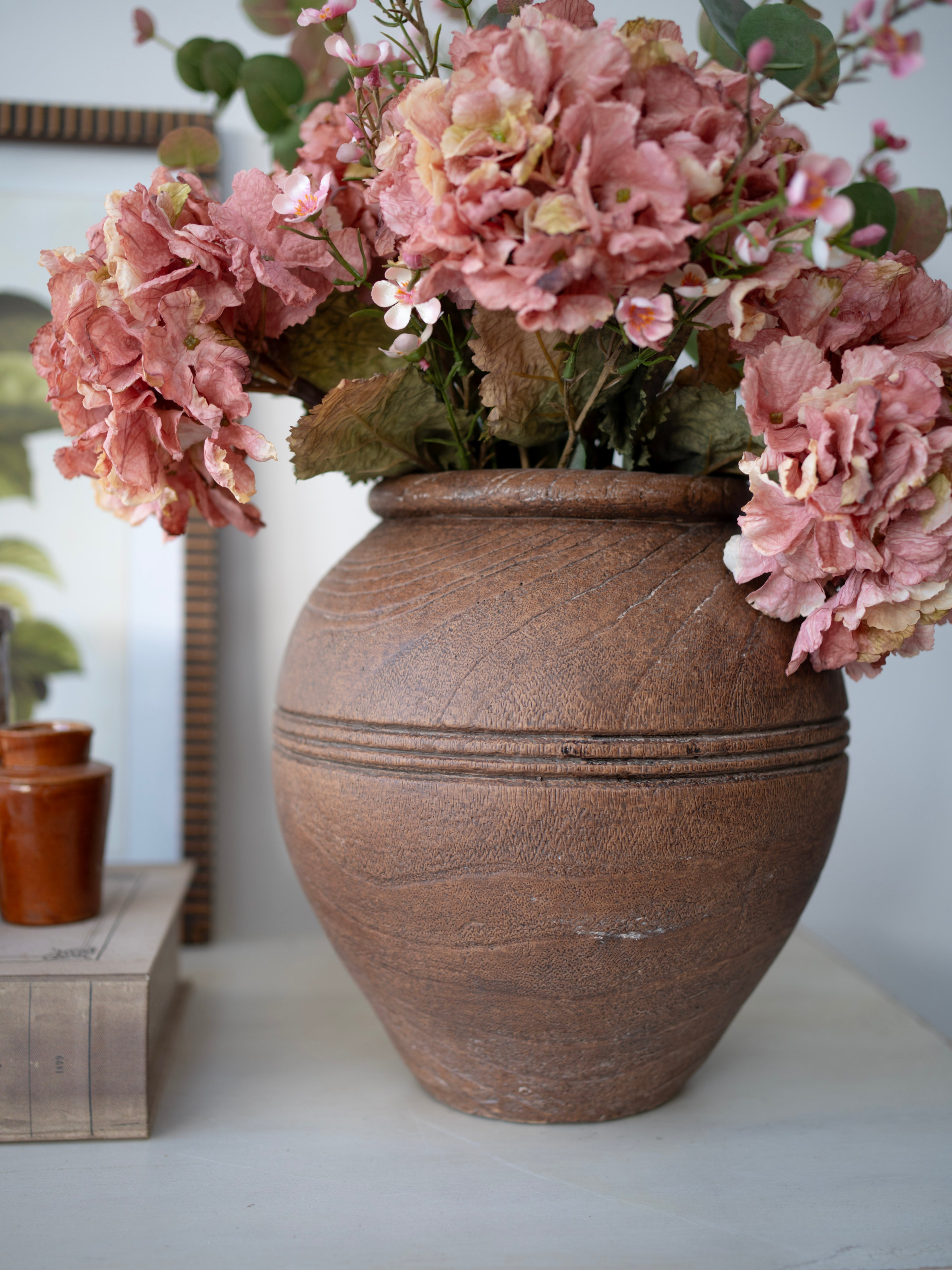Decorative vase with pink flowers on a surface