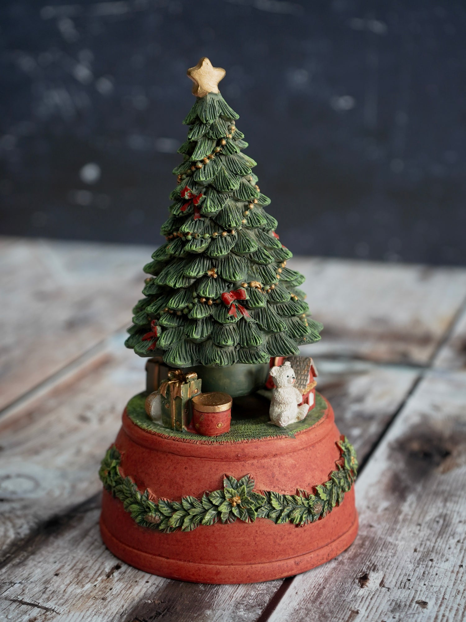 Decorative Christmas tree figurine on a wooden surface with a dark background