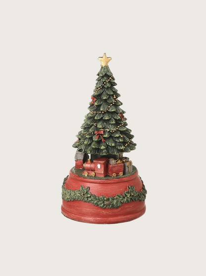 Decorative Christmas tree with train and star on a red base against a white background