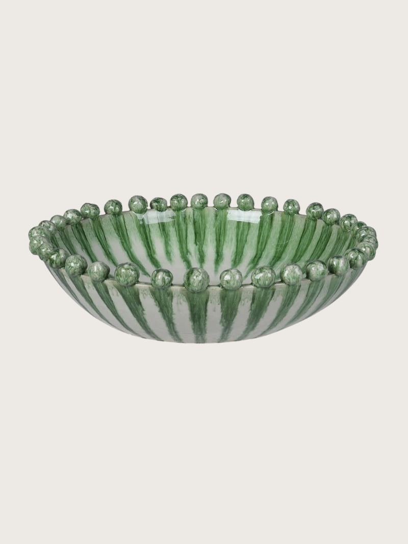 Green dripping effect ceramic bowl with bead-like decorations on a light gray background