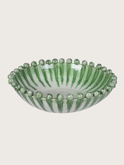 Decorative green dripping effect bowl with green stripes and bead-like accents on a light gray background
