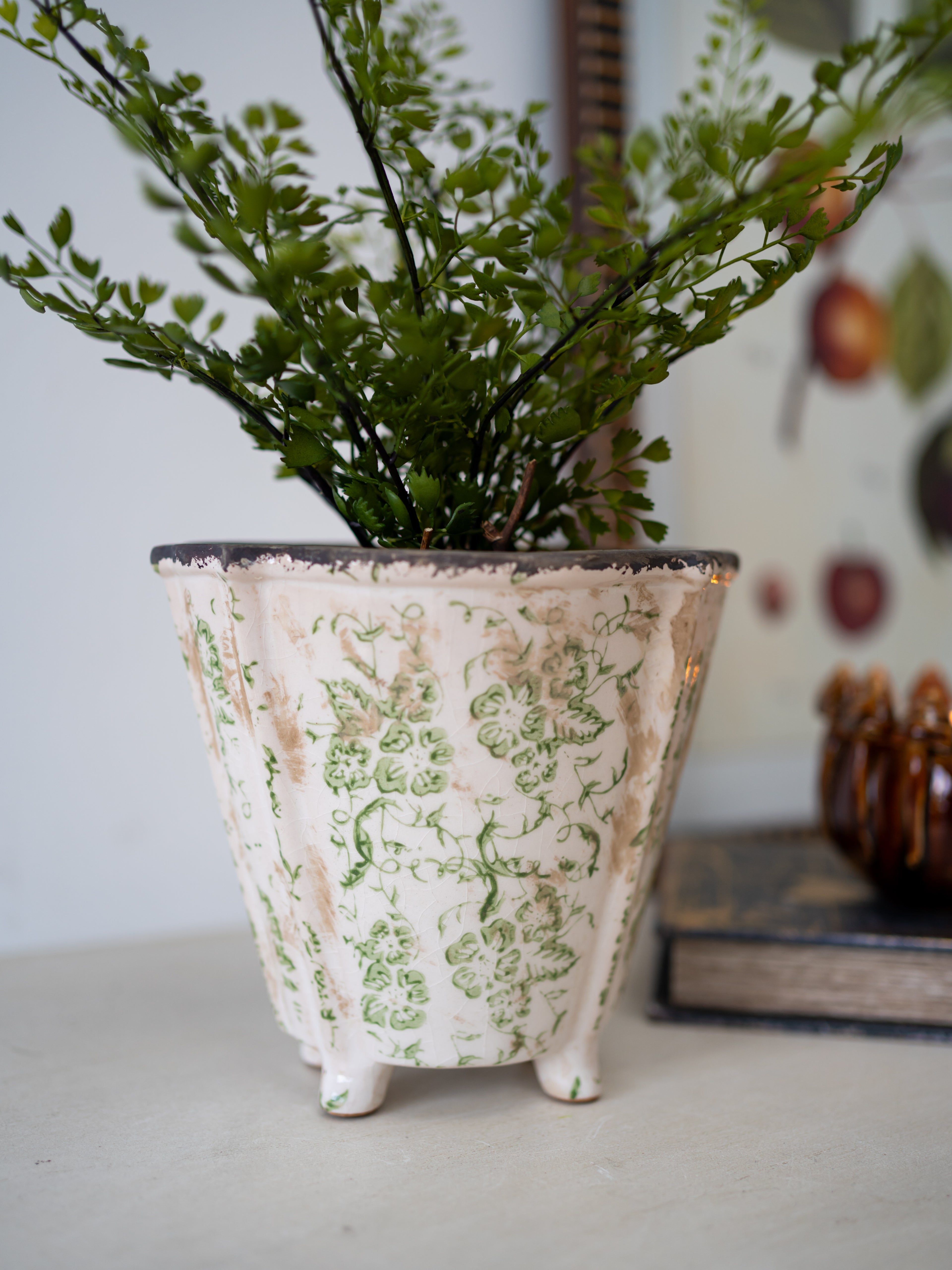 Decorative plant pot with floral pattern on a white surface for home styling and decor