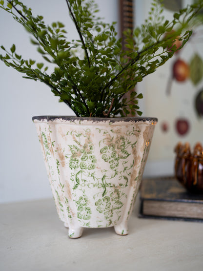 Decorative plant pot with floral pattern on a white surface for home styling and decor