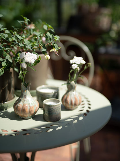 Small vases with flowers on a decorative table outdoors