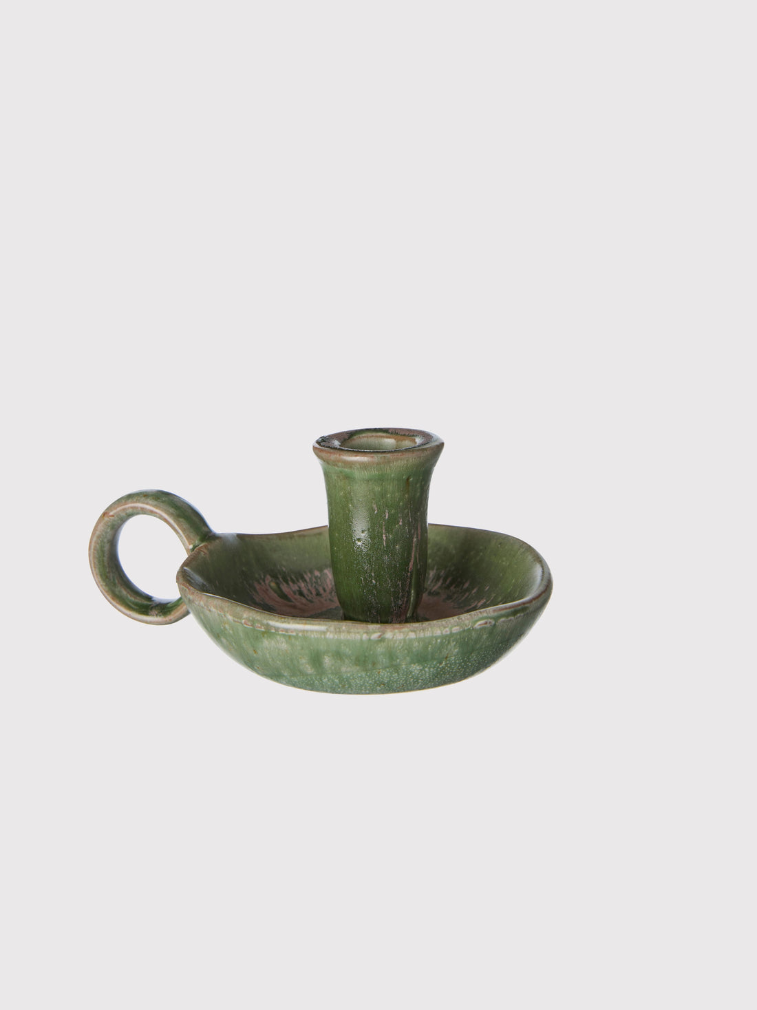 Green ceramic candle holder on a light gray background