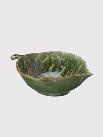 Green ceramic leaf-shaped bowl on a light gray background