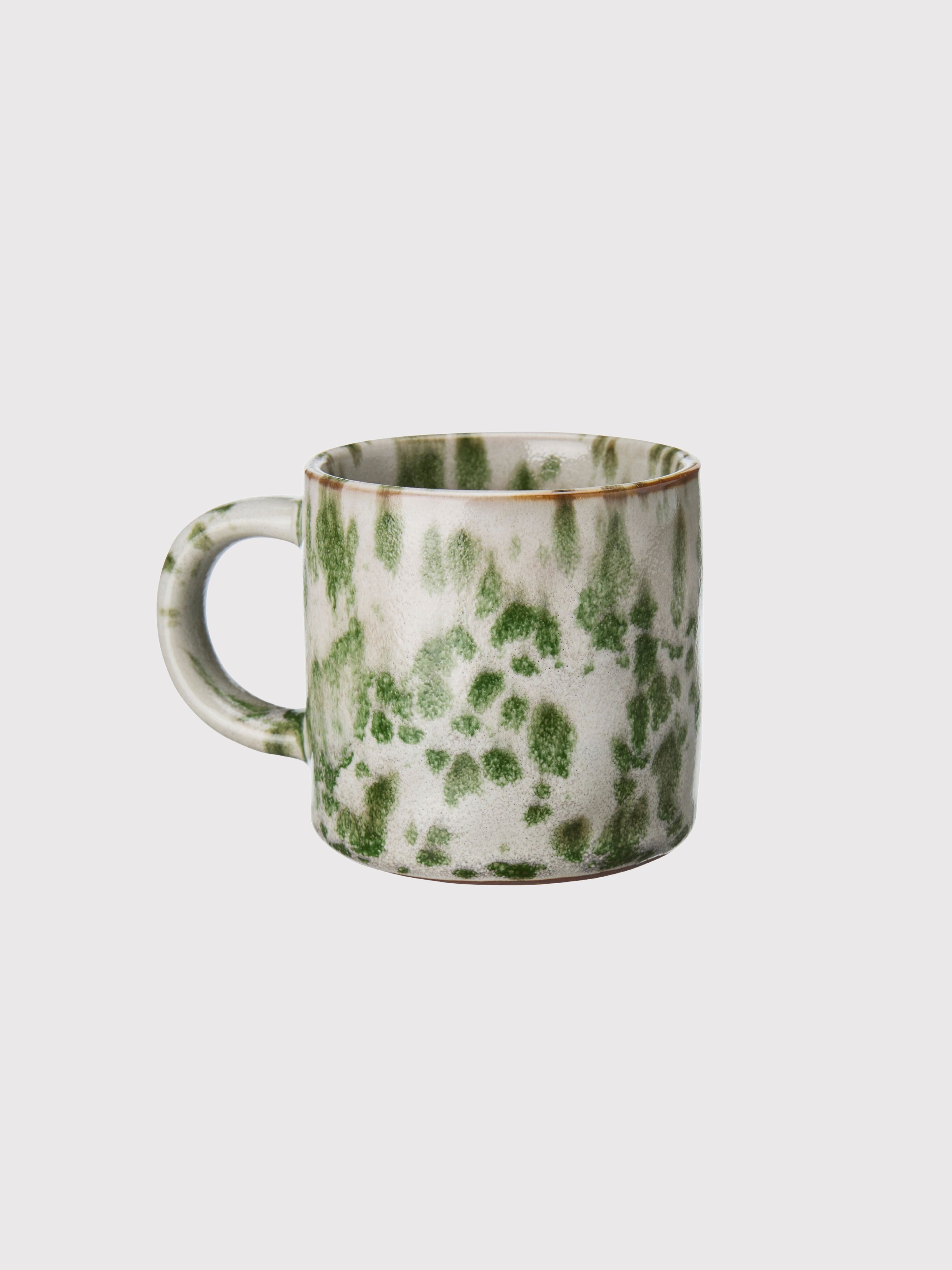 Green and white marbled ceramic mug on a light gray background