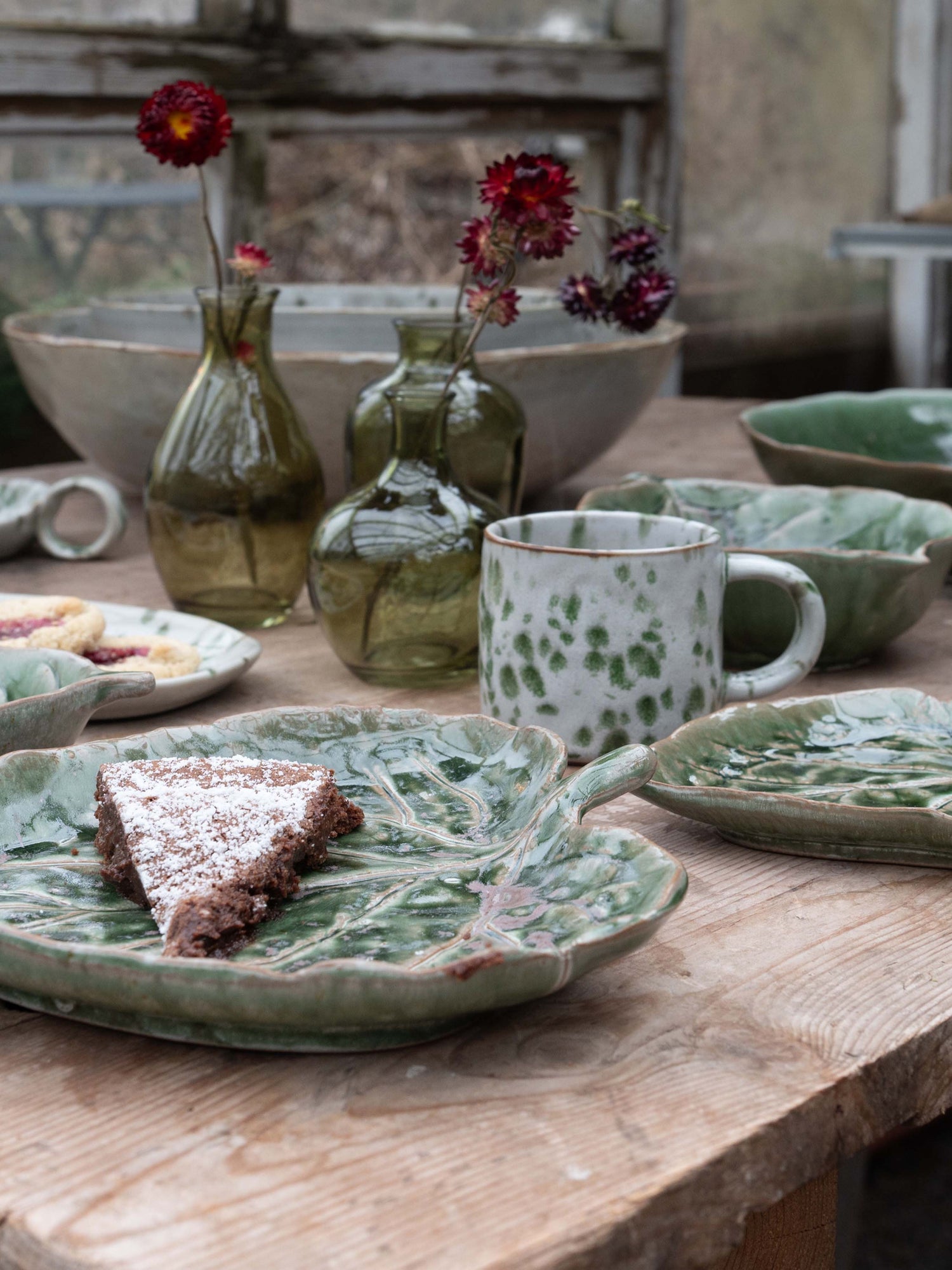Ceramic dishes and vases on a wooden table with a rustic background