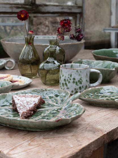 Ceramic dishes and vases on a wooden table with a rustic background