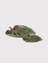 Green ceramic leaf-shaped platter on a white background