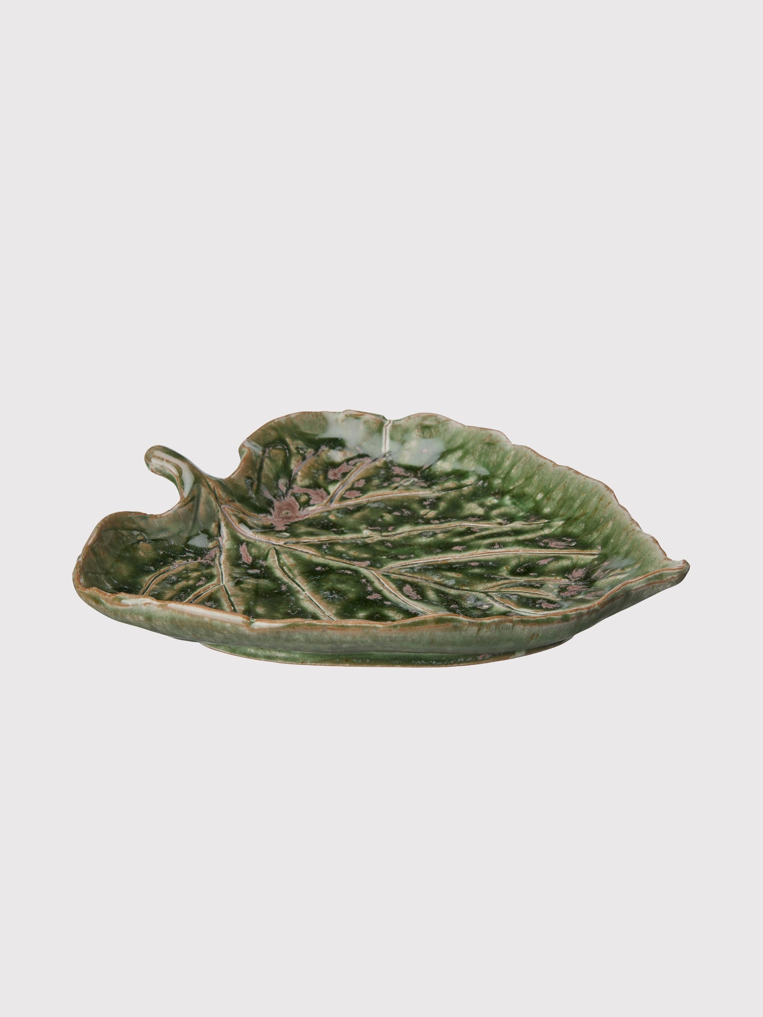 Green ceramic leaf-shaped dish on a white background