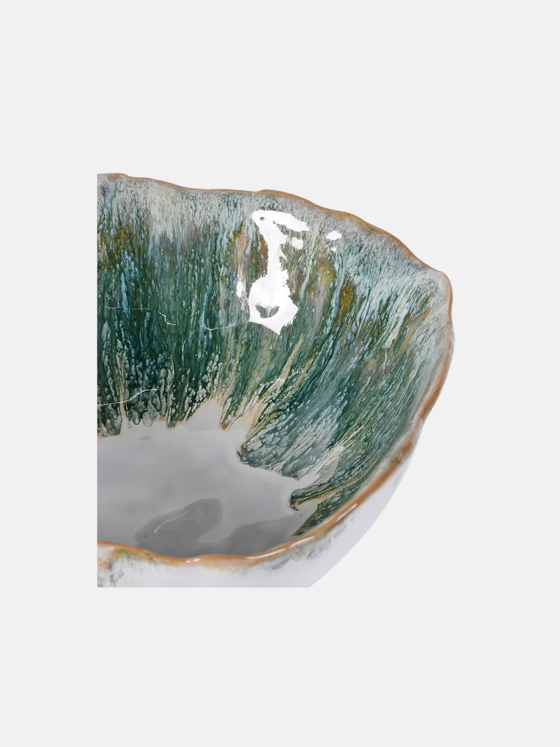 Ceramic bowl with green and white glaze on a white background