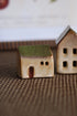 Two small ceramic houses on a textured surface with a blurred background