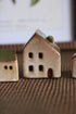 Three ceramic houses on a textured surface with a blurred background