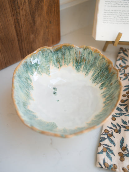 Ceramic bowl with green and beige rim on a white surface