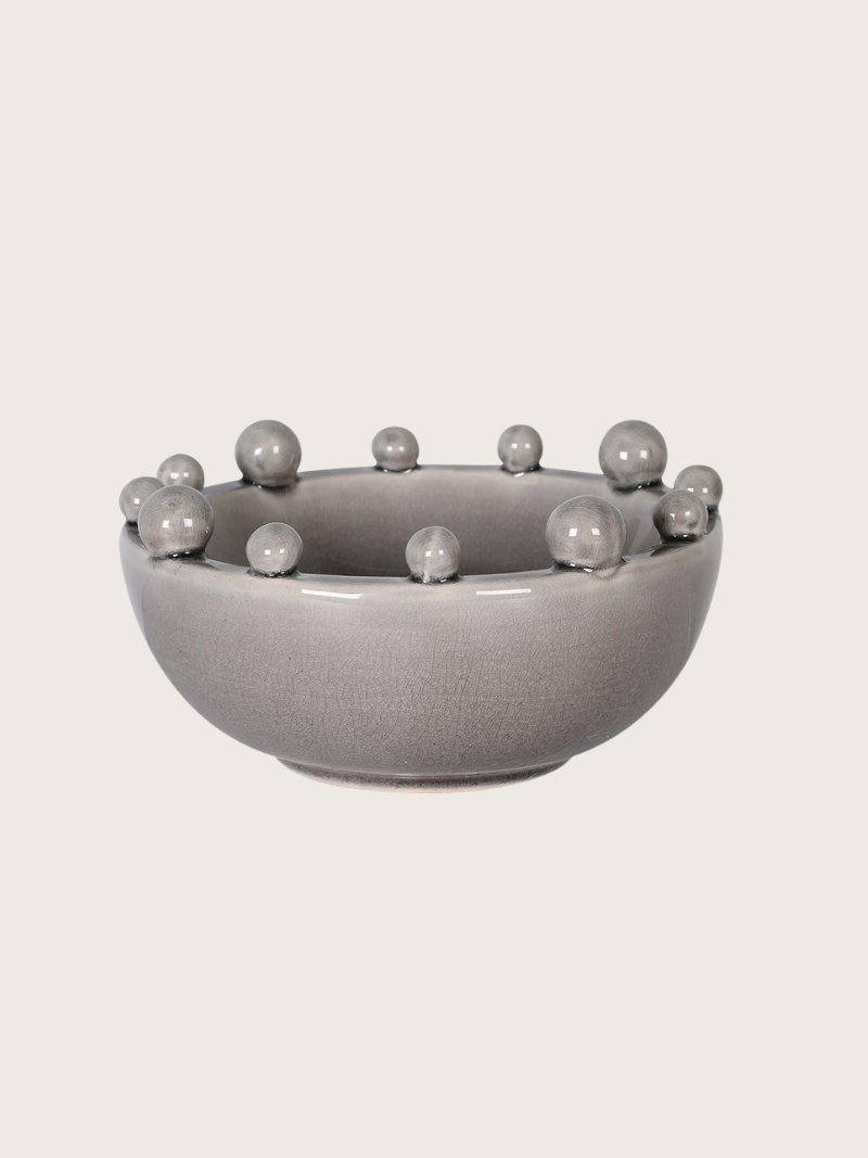 Gray ceramic bowl with bobble protrusions on a light gray background