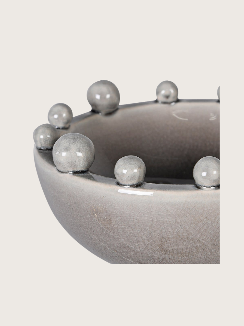 Gray ceramic bowl with bobble protrusions on a light gray background