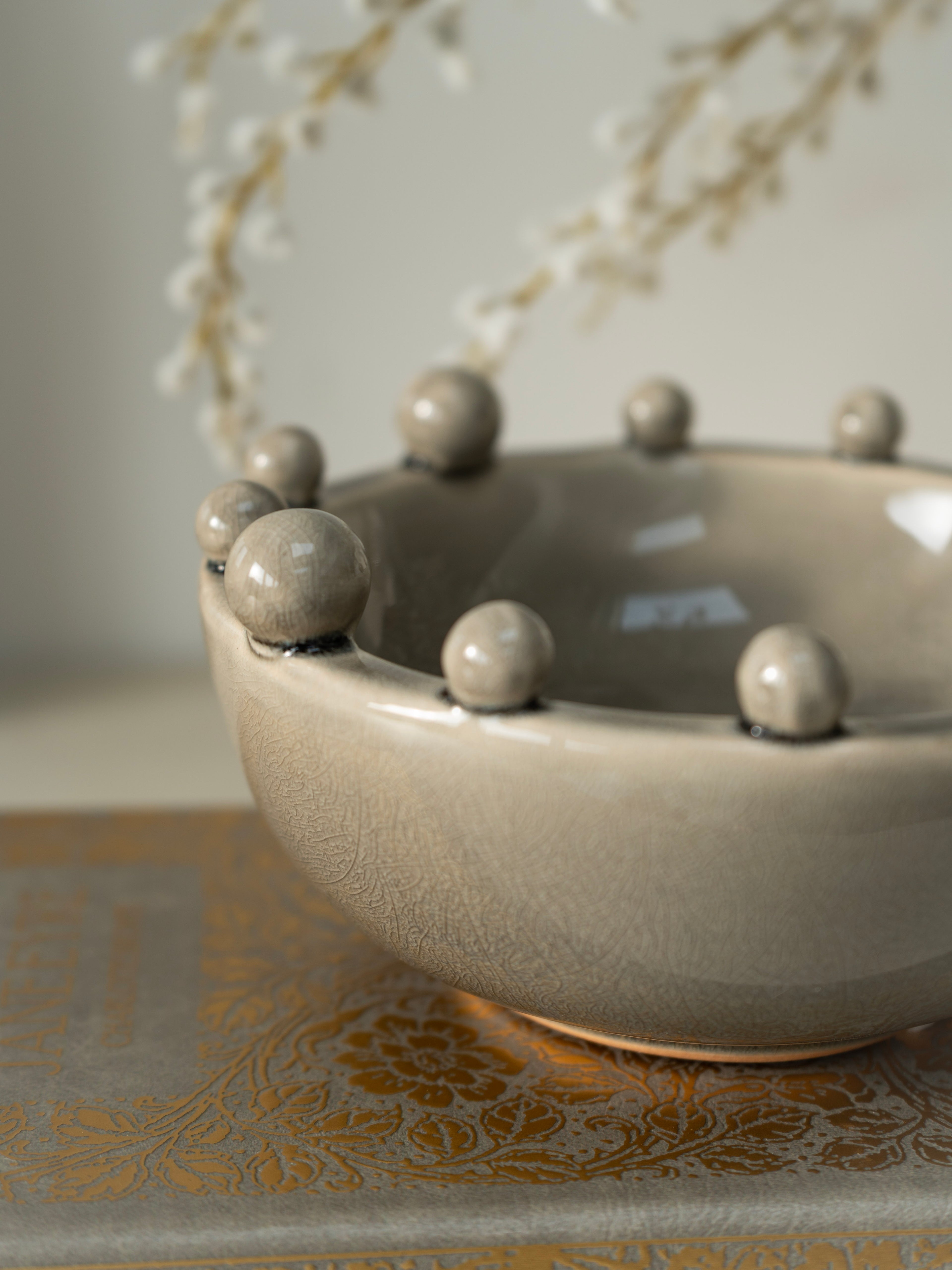 Ceramic bowl with spherical bobble protrusions on a textured surface