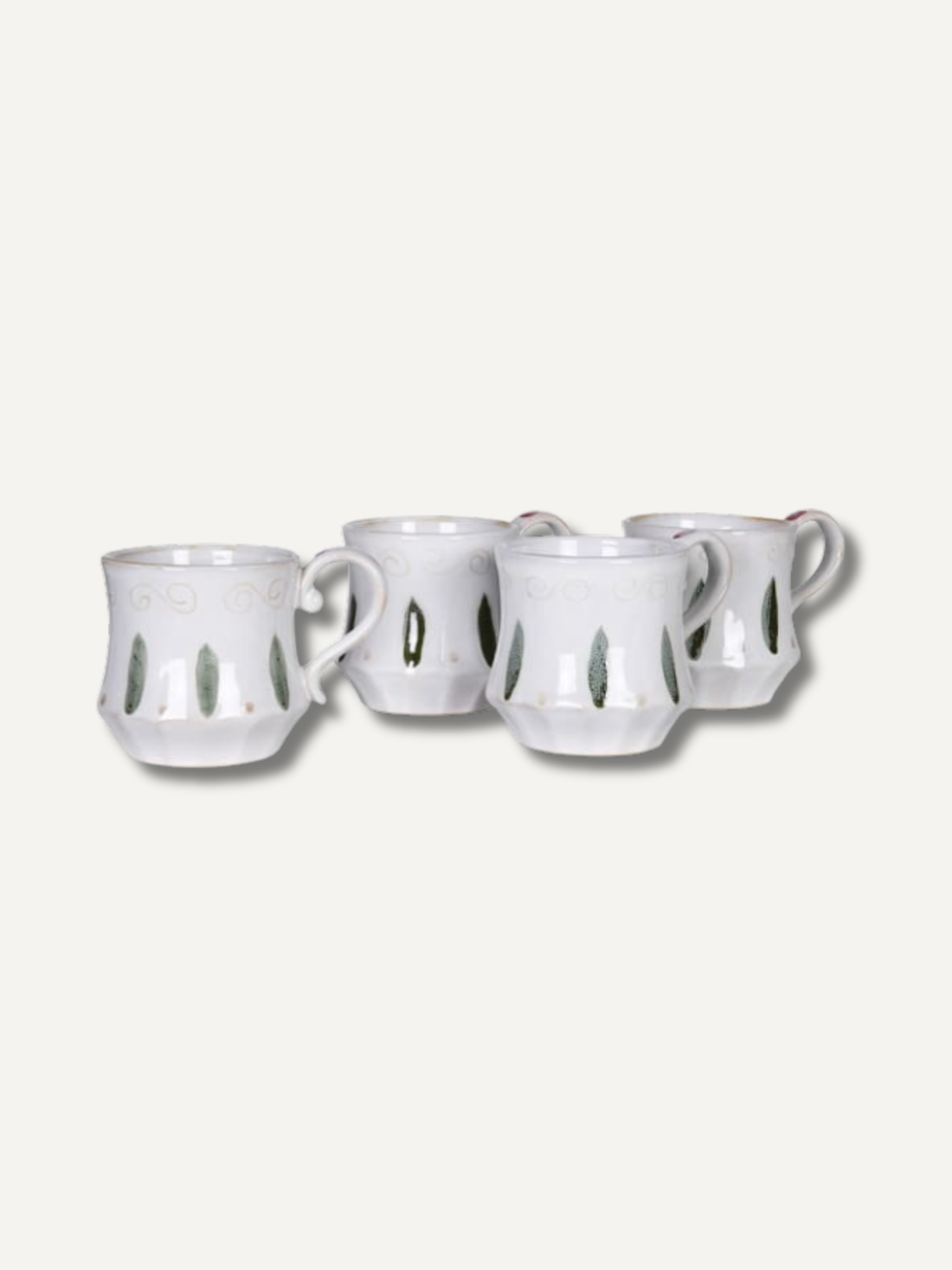 Set of four white ceramic mugs with decorative cutouts on a light gray background