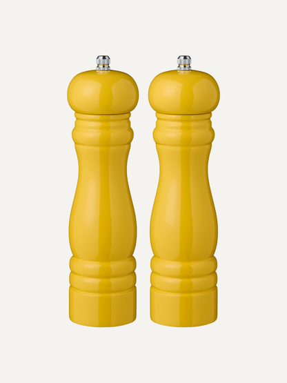 Two harvest yellow salt and pepper wooden mills on a white background, kitchen styling ideas for a pop of funky colour