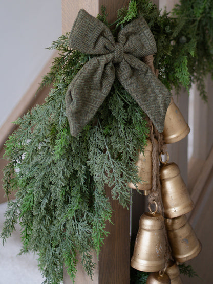 Decorative garland with greenery and gold bells on a staircase
