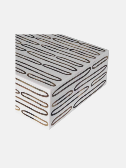 White rectangular box with black and gold geometric pattern on a white background