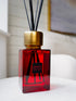 Red kings road sences diffuser bottle with gold cap on a white surface