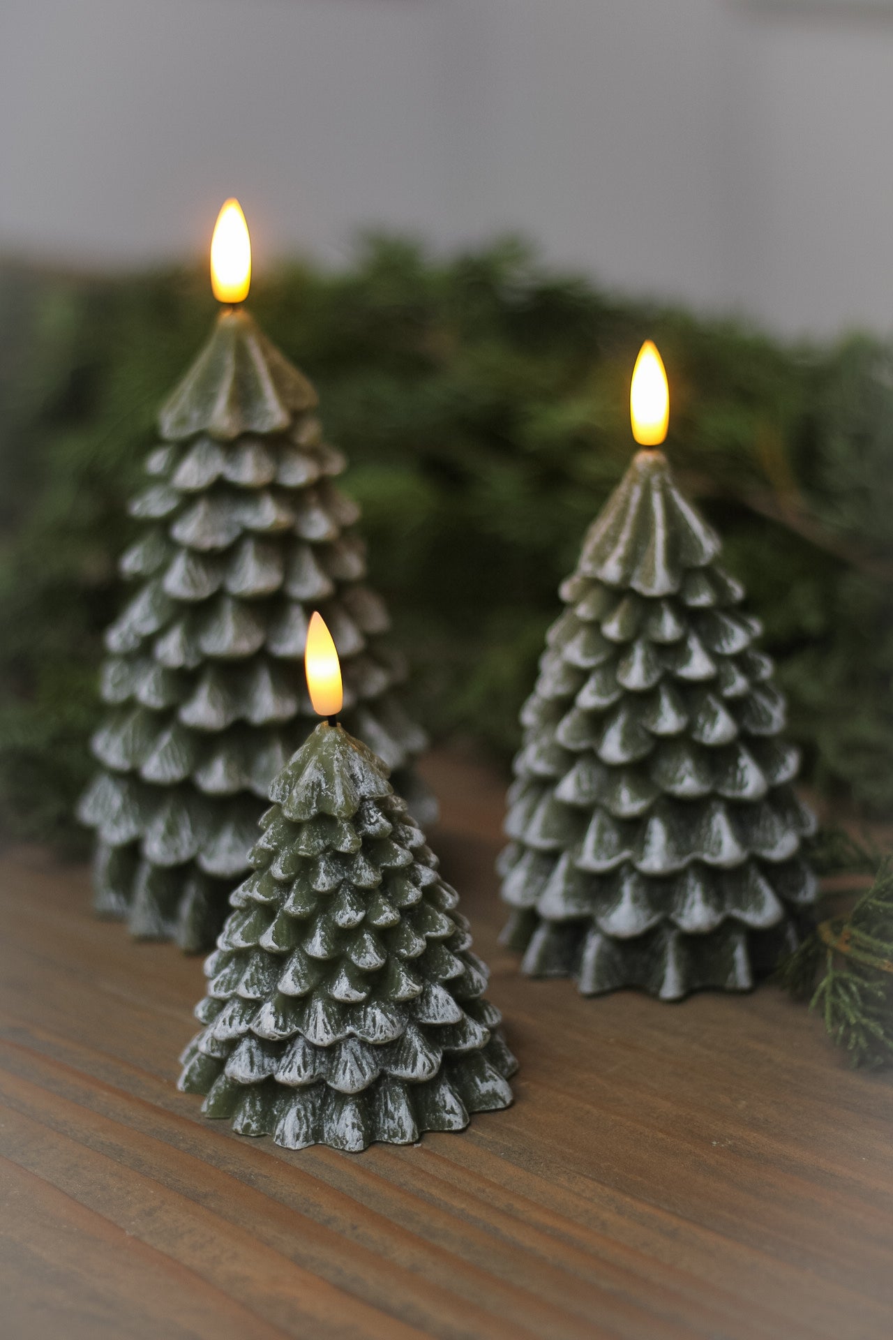 Flameless LED candle with etched tree shape and dusted white snowlike look to deep green festive christmas tree