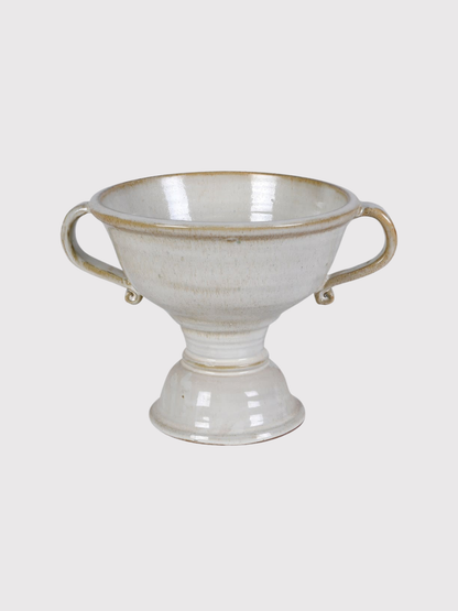 White ceramic urn vase with handles on a light gray background