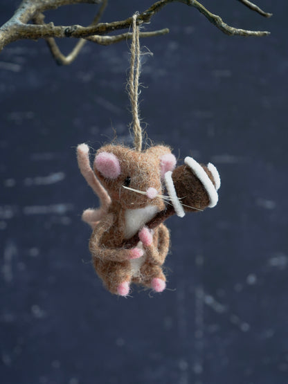 Felted mouse ornament hanging from a branch against a dark background