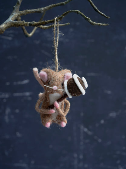 Plush toy mouse with a bow tie hanging from a branch against a dark background