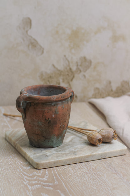 small mini vintage olive pot on marble board with dried poppy heads