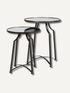Two round metal side tables with glass tops on a white background