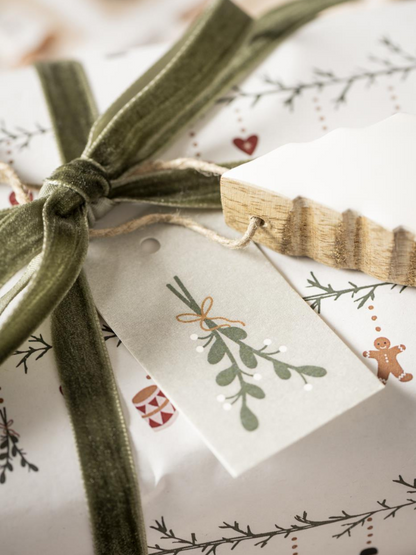 Gift wrapped in festive paper with a moss green velvet  ribbon and decorative tag.