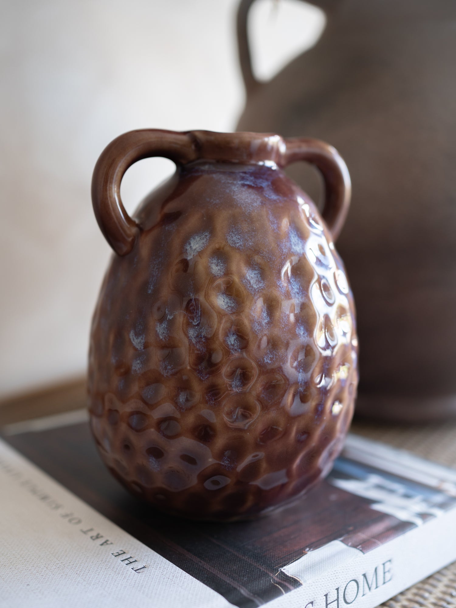 Mulberry textured ceramic vase on a surface with a blurred background