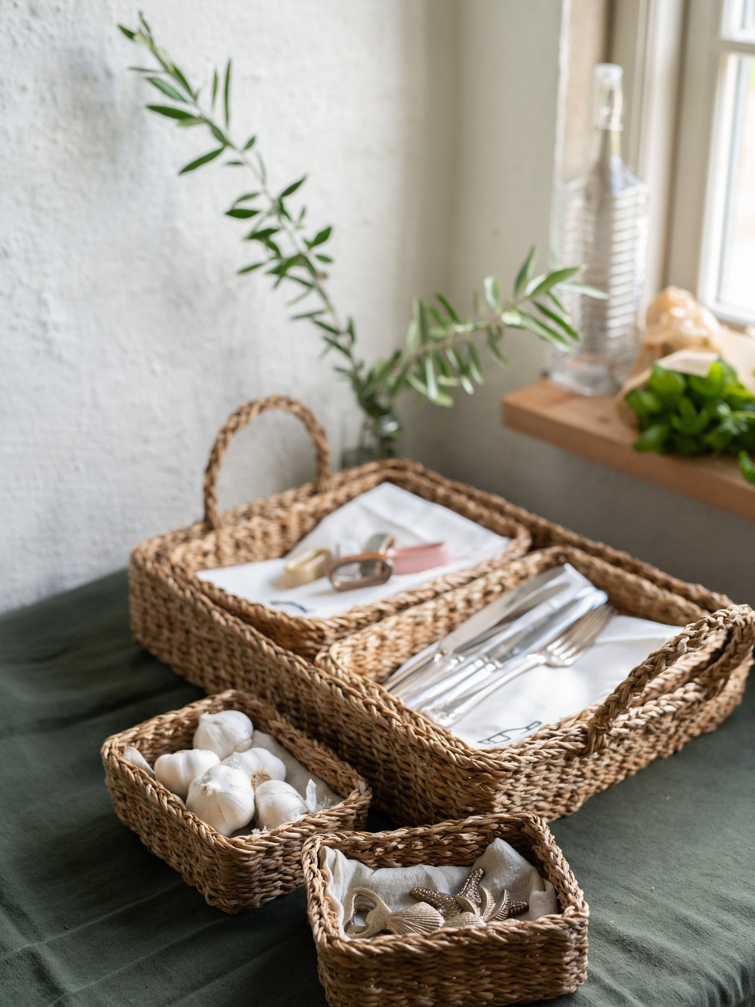 Set of woven baskets with tableware on a surface with a neutral background