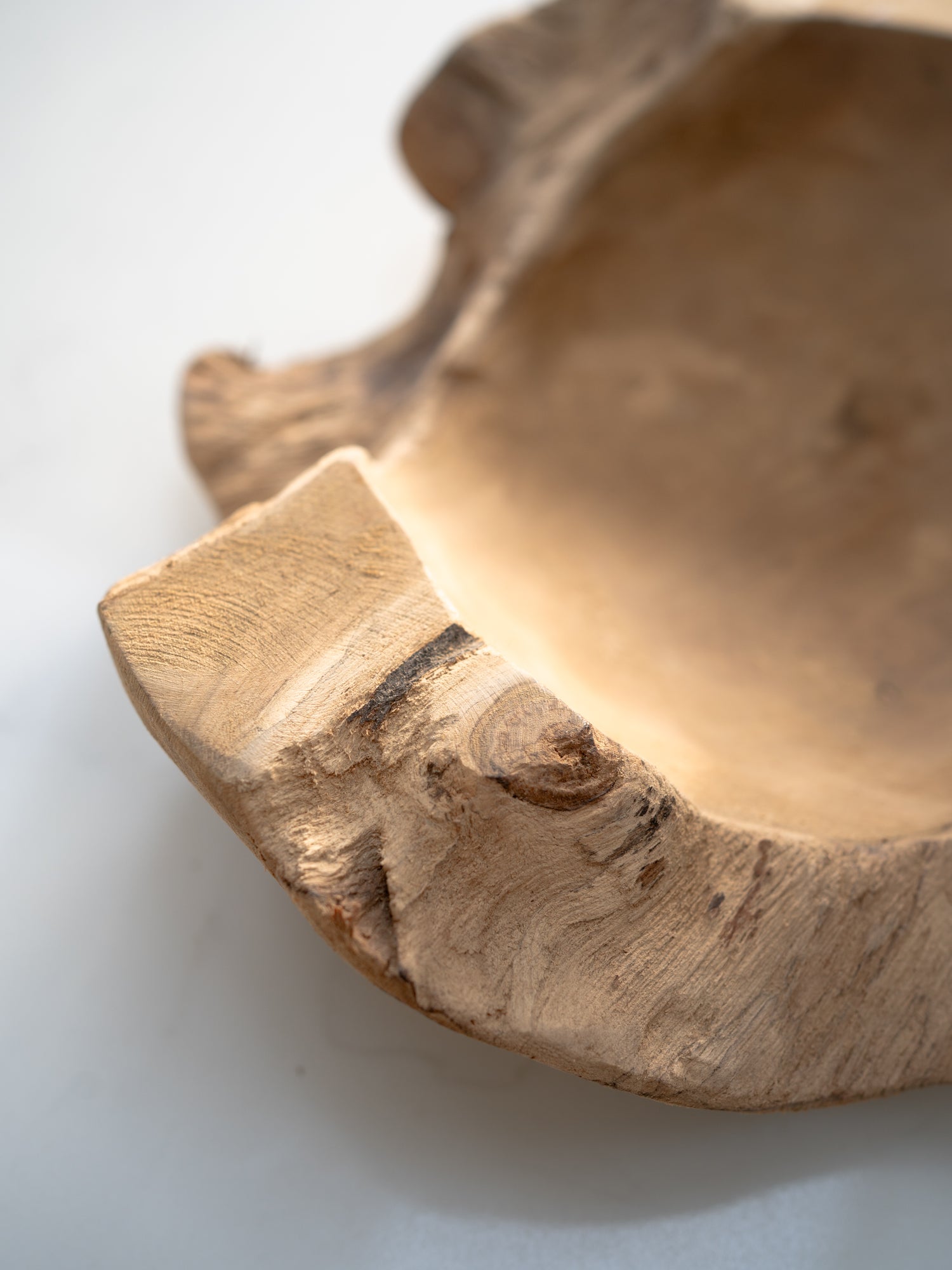 Close-up of a wooden bowl with natural edge on a light background