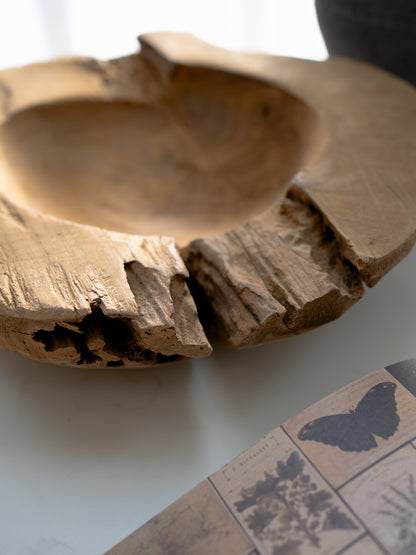 Wooden bowl with natural edge on a white surface