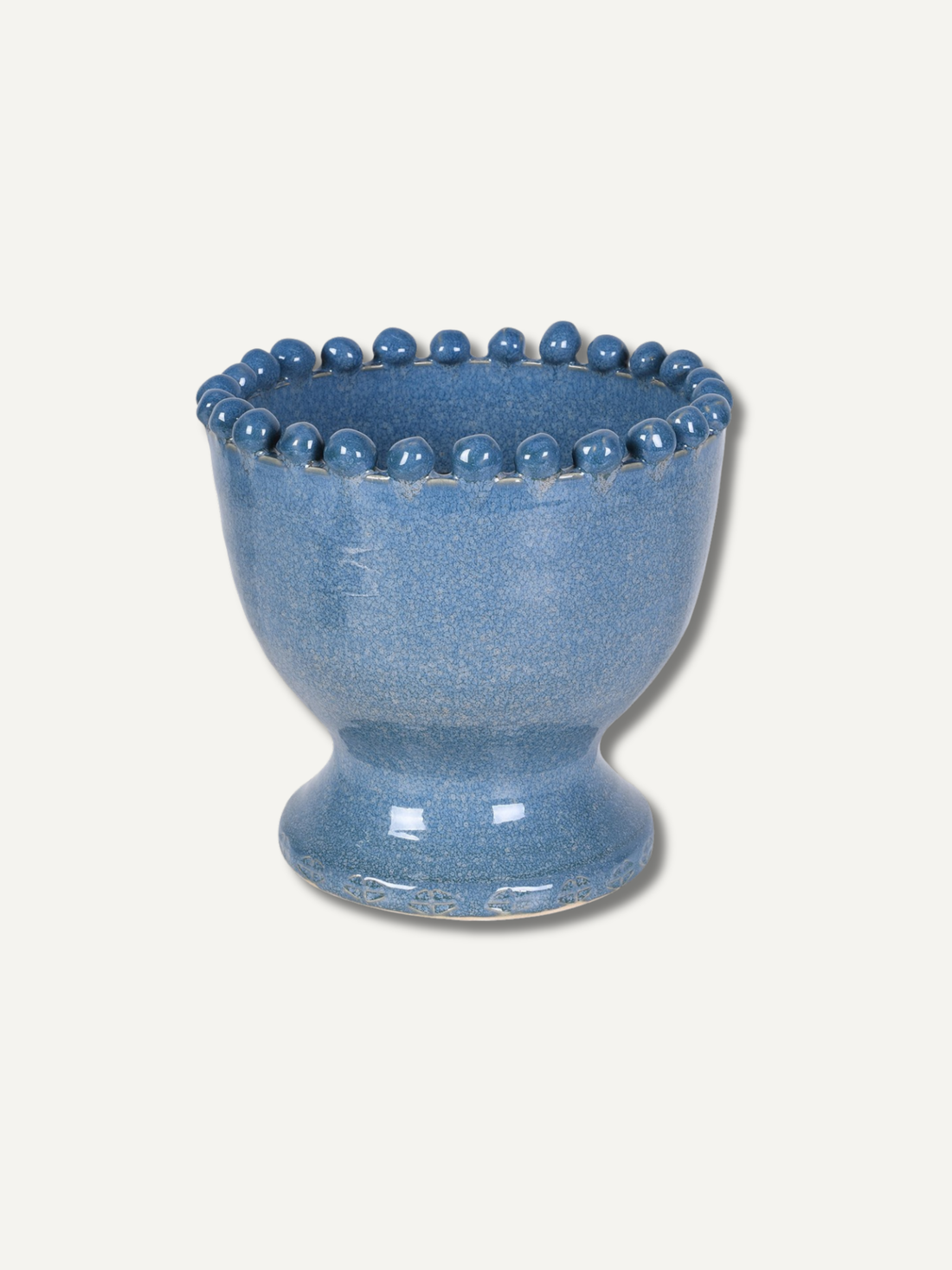 A small blue ceramic vase with a flared rim decorated with a row of raised round beads, shown on a plain light beige background.