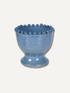 A small blue ceramic vase with a flared rim decorated with a row of raised round beads, shown on a plain light beige background.
