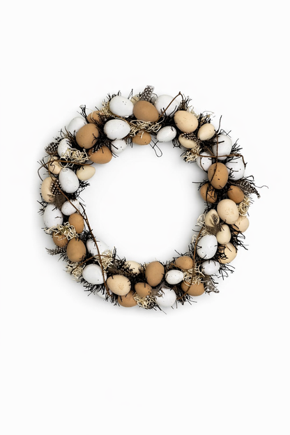 Decorative wreath made of eggs and feathers on a white background