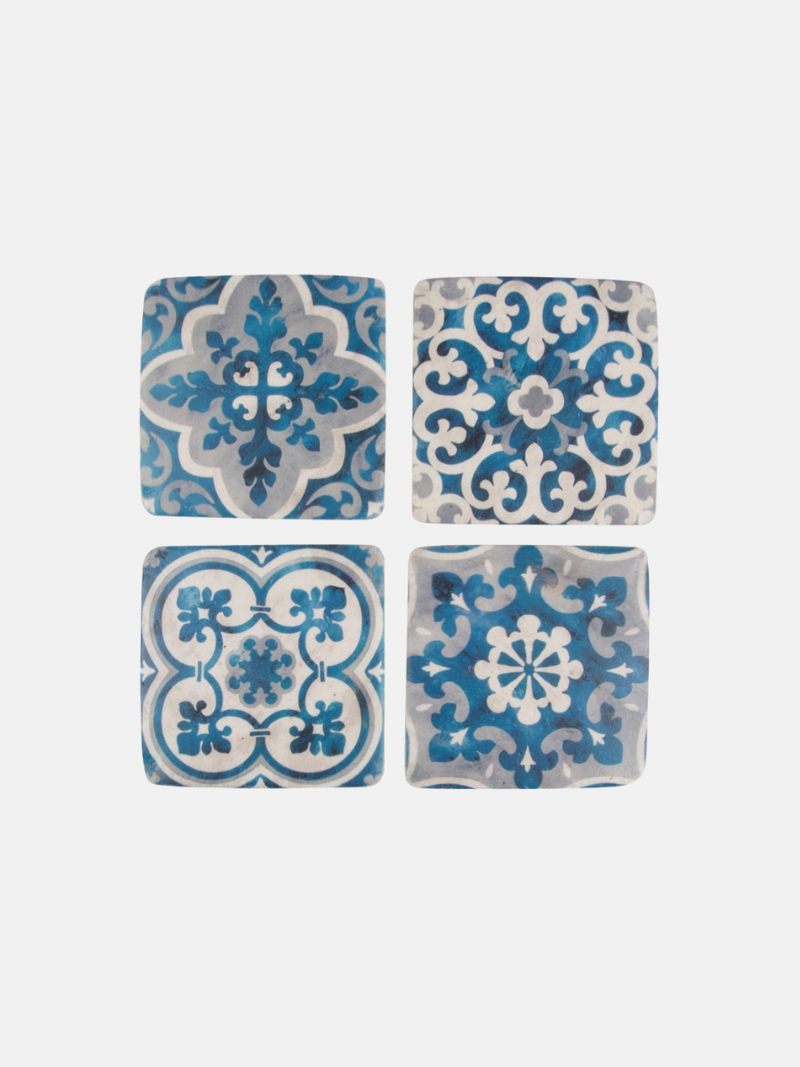 Four blue and white patterned coasters on a white background