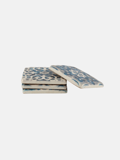 Set of four decorative coasters with blue patterns on a white background