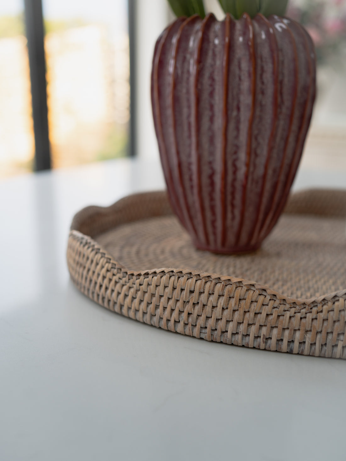 Decorative vase on a woven tray with a blurred background