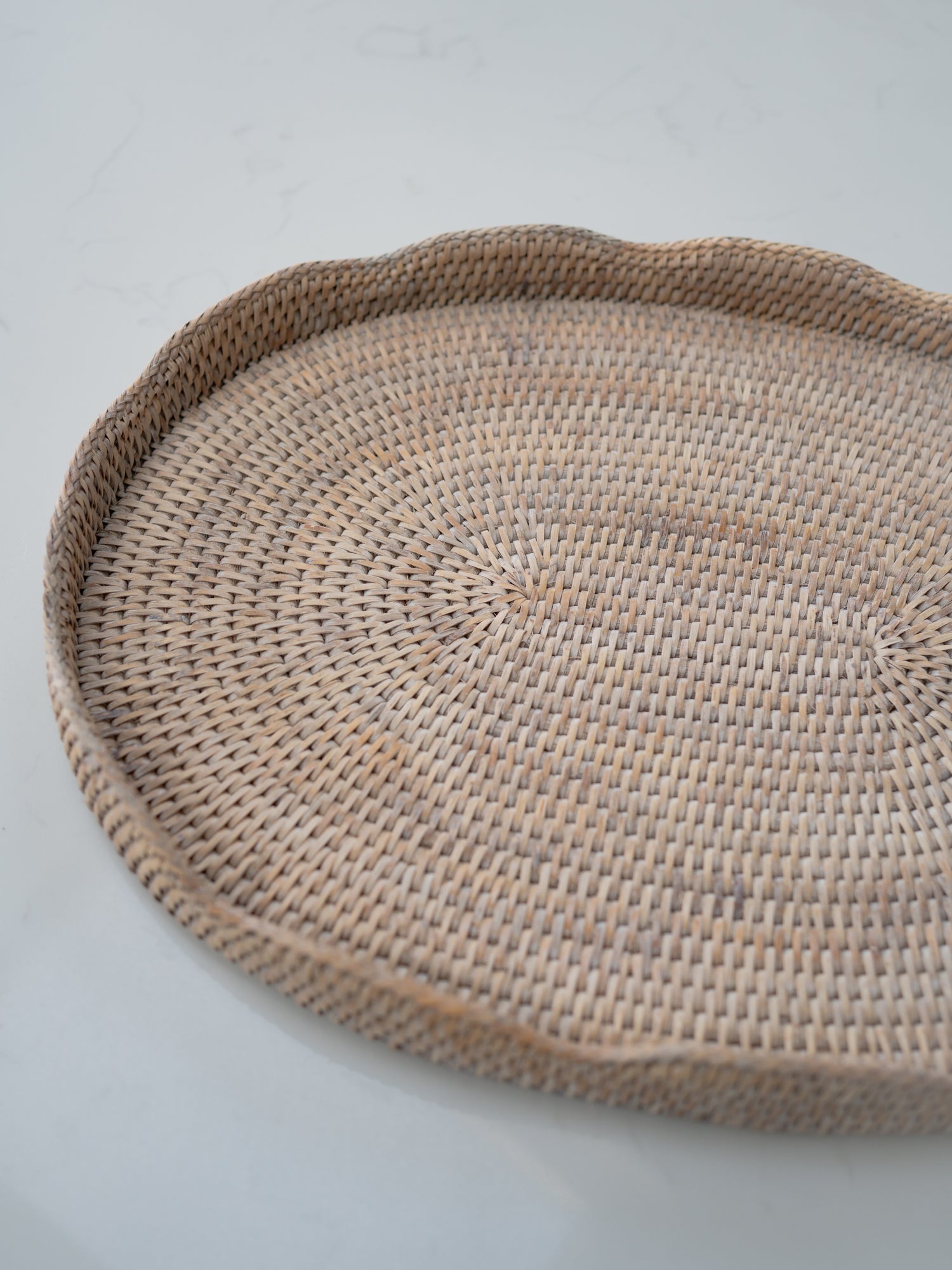 Woven round tray on a light gray background